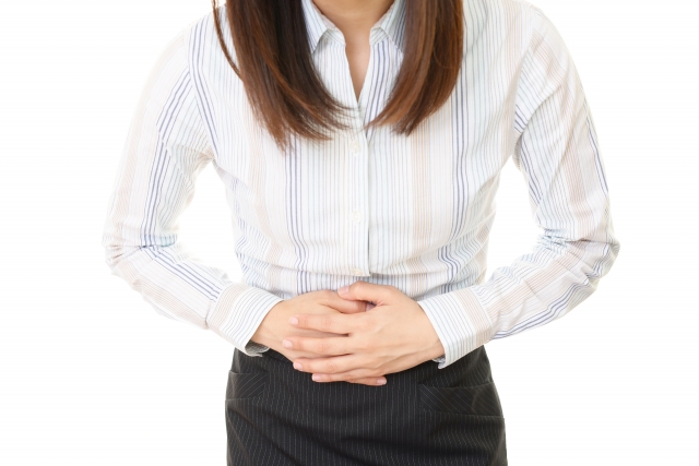 お腹をおさえる女性